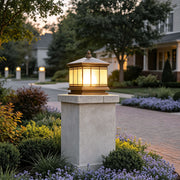 Waterproof outdoor gate pillar light mounted on a stone post beside a landscaped residential driveway.