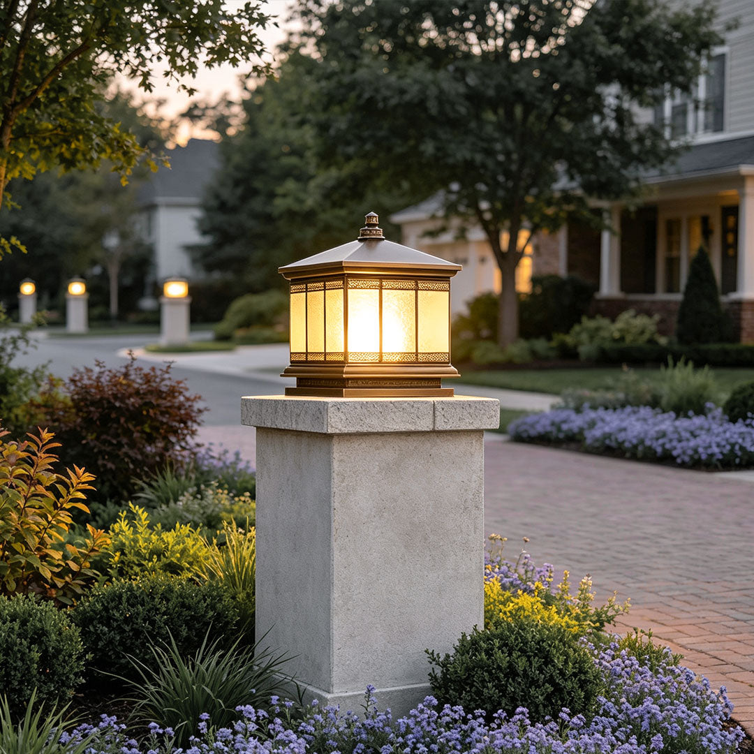 Waterproof outdoor gate pillar light mounted on a stone post beside a landscaped residential driveway.