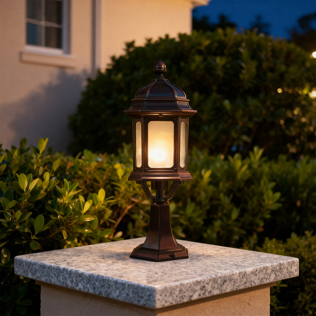 Waterproof outdoor pendant light with warm LED glow mounted on textured stone pedestal at dusk