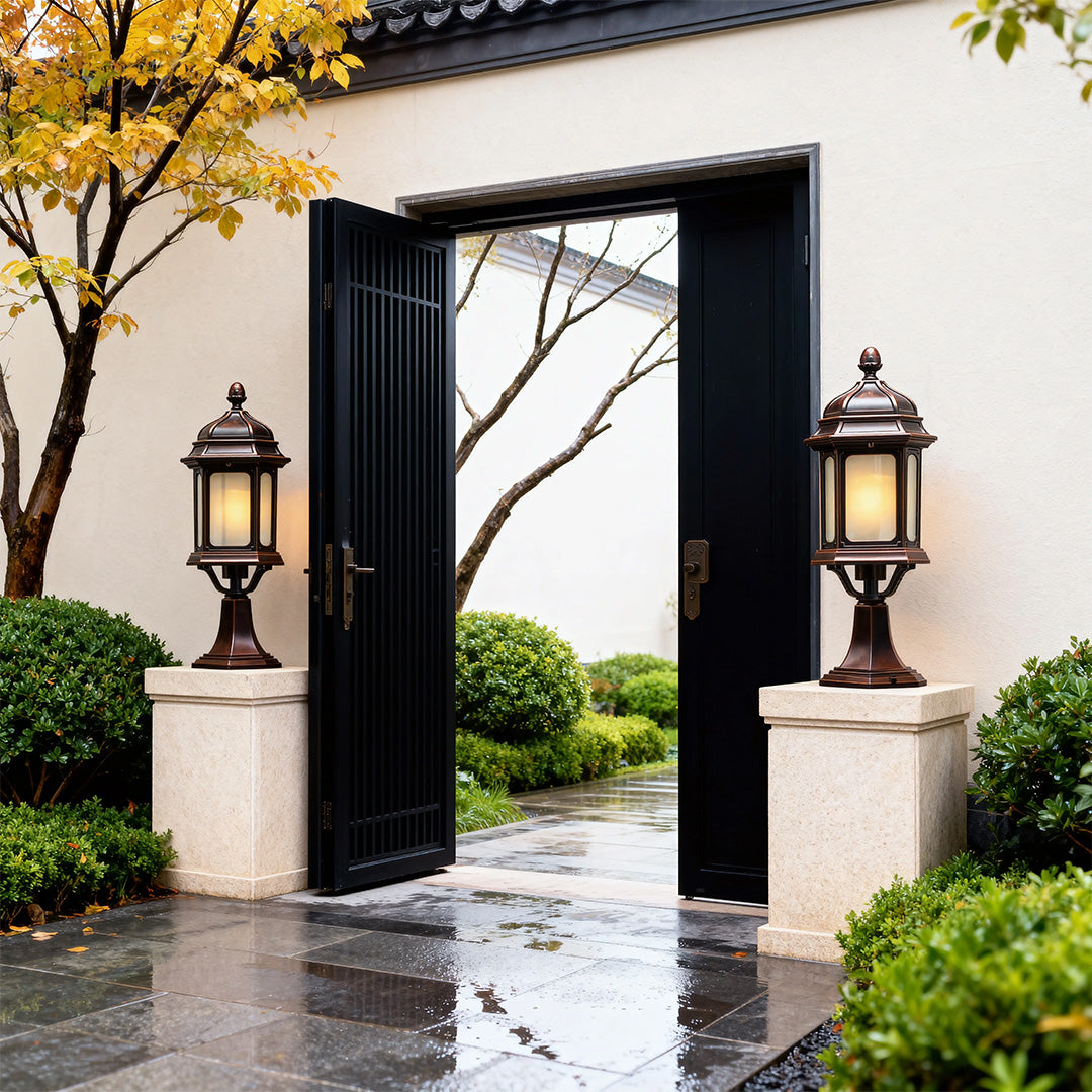 Matching waterproof outdoor pendant lights mounted on white columns flanking modern black entrance gate