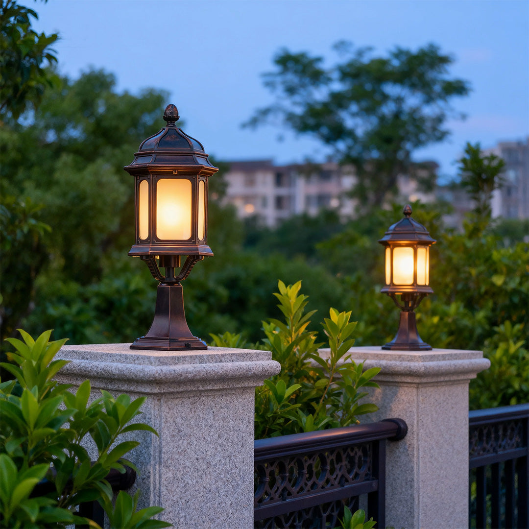 Two waterproof outdoor pendant lights providing soft illumination on granite posts in residential landscape