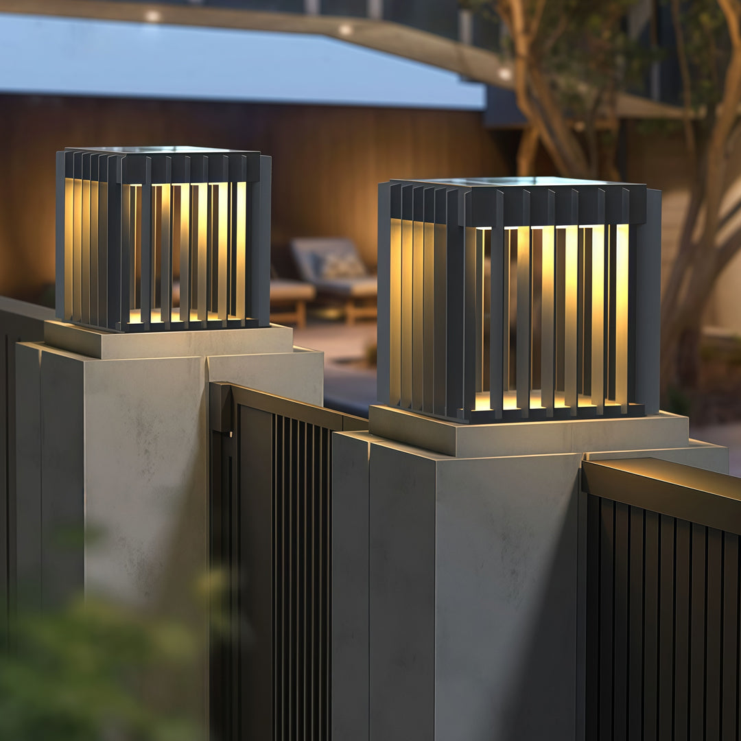 Multiple waterproof outdoor pillar lights arranged along a landscaped walkway, providing uniform warm illumination.