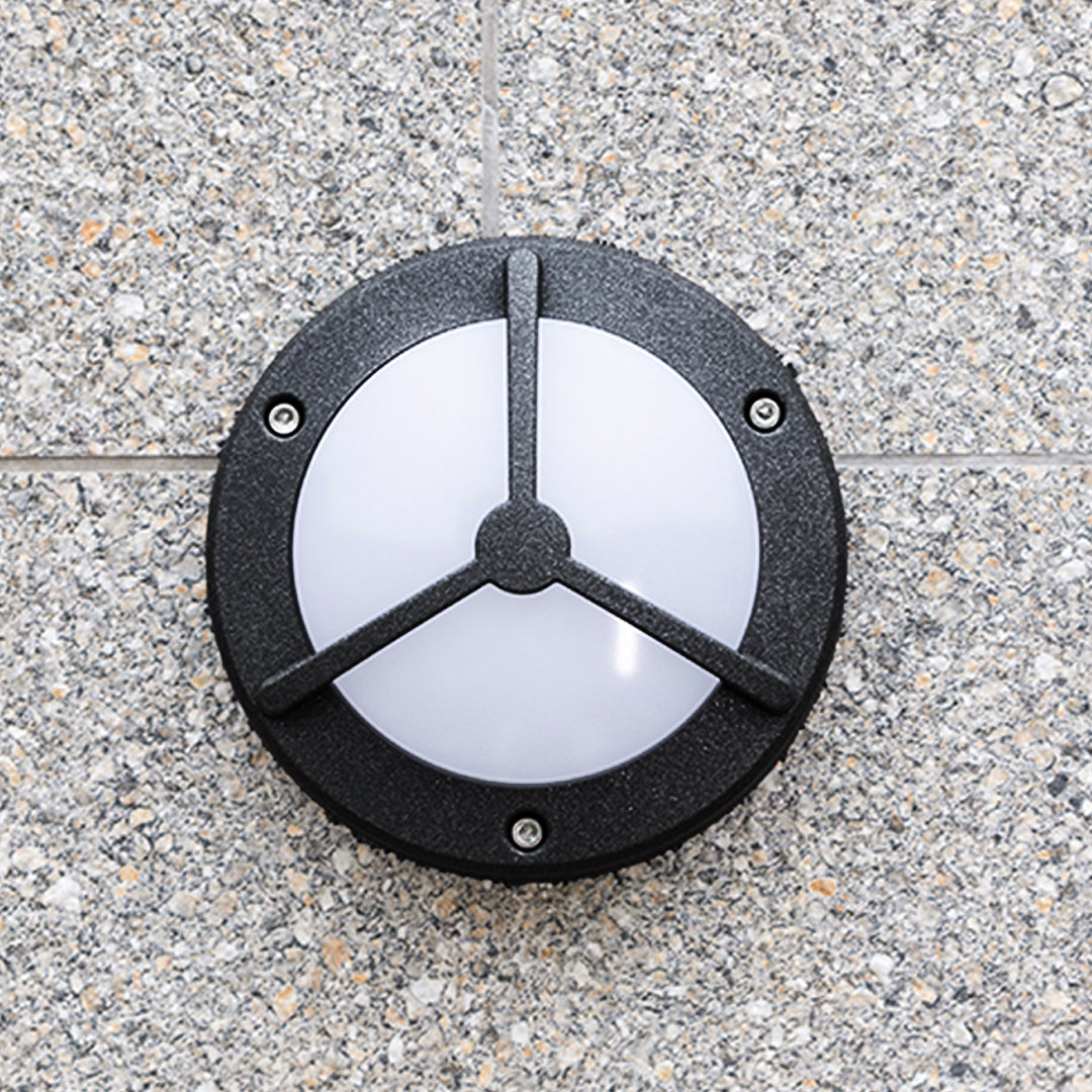 Waterproof outdoor wall lighting installed on grey concrete with three-spoke illuminated pattern