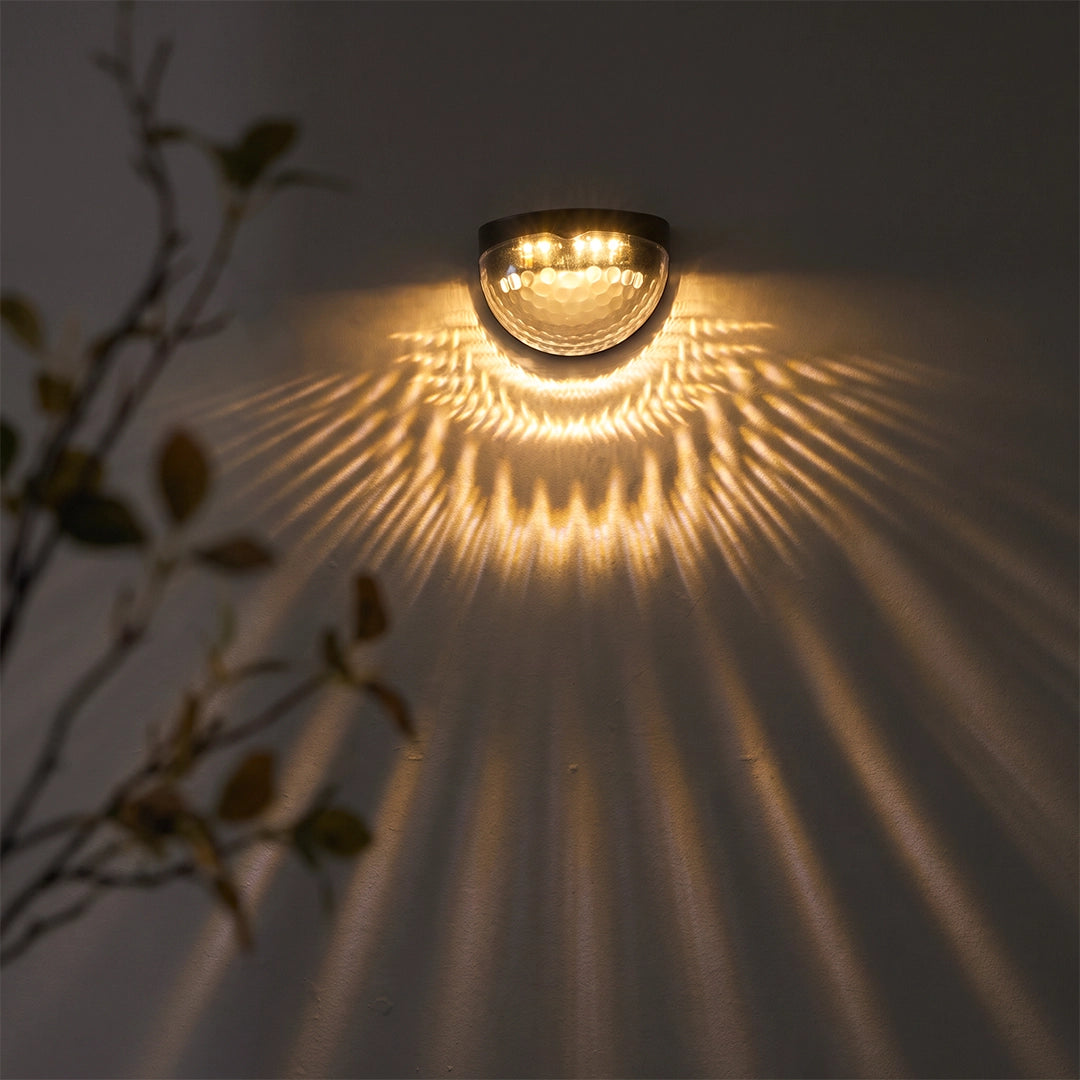 Waterproof solar fence lights creating a wide fan-shaped light pattern on an exterior wall.