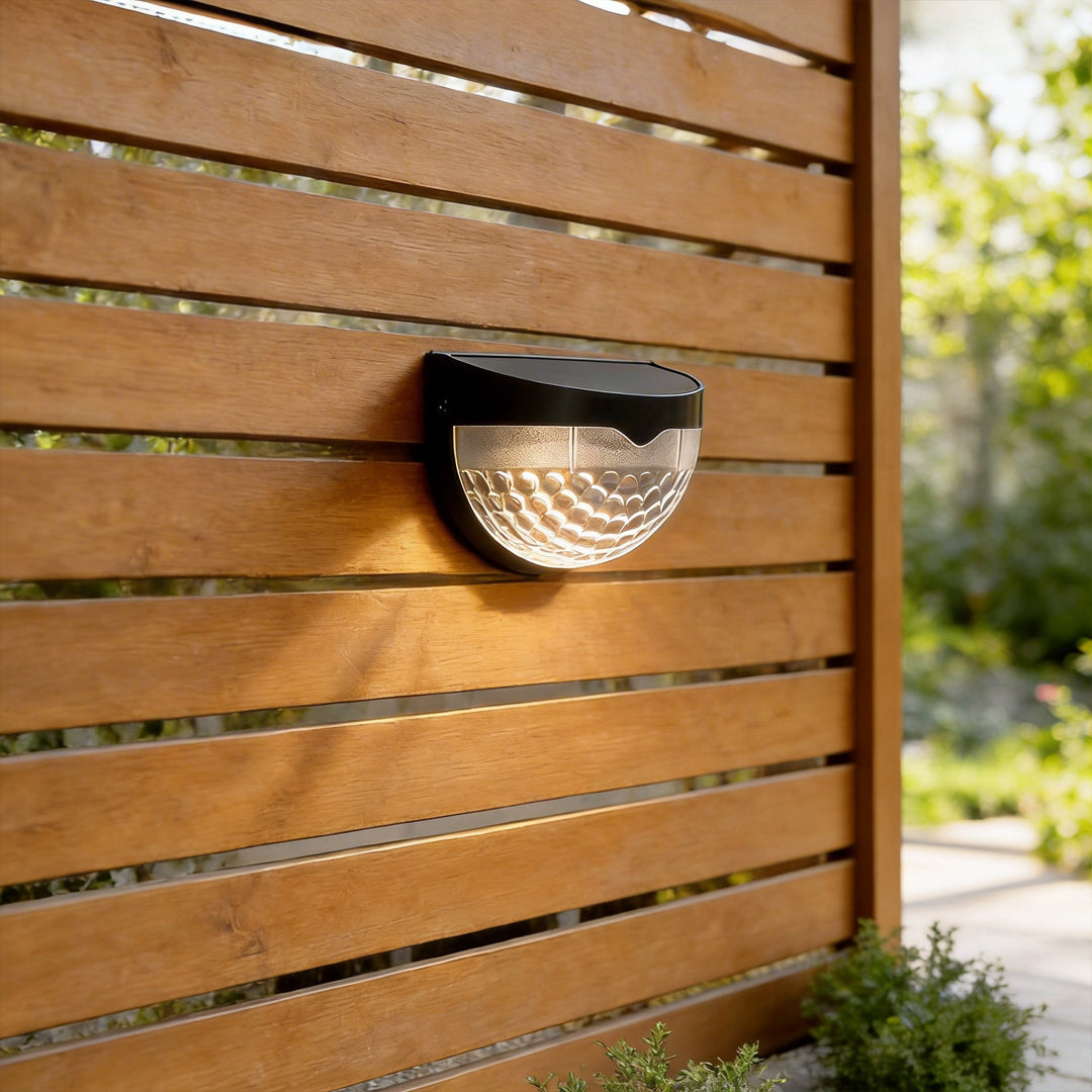 Waterproof solar fence lights mounted on a wooden fence panel for warm outdoor accent lighting.