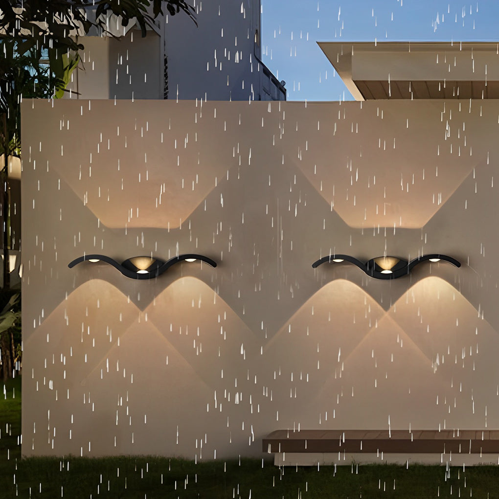 Close-up of a black wave wall sconce showing textured metal finish and integrated LED light source.