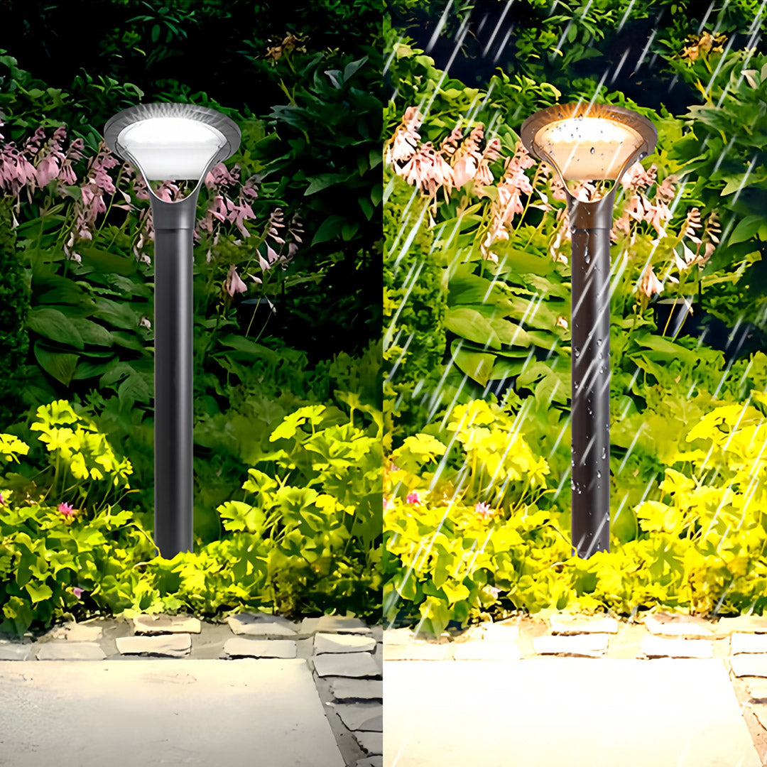 Weatherproof solar bollard lights illuminating a winding stone pathway and dense green foliage on a rainy night.
