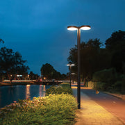 Well-lit outdoor street light casting warm light along a wide walkway.