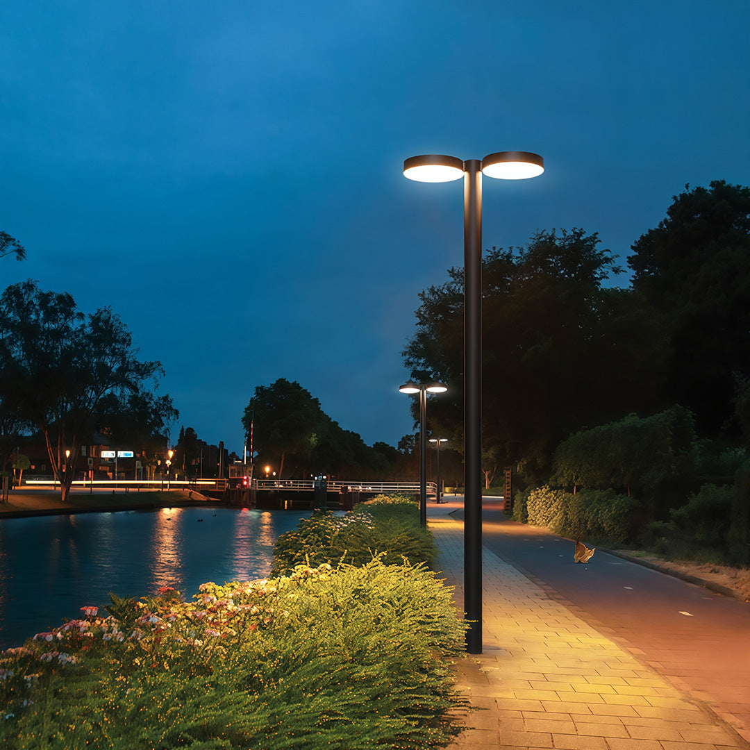 Well-lit outdoor street light casting warm light along a wide walkway.