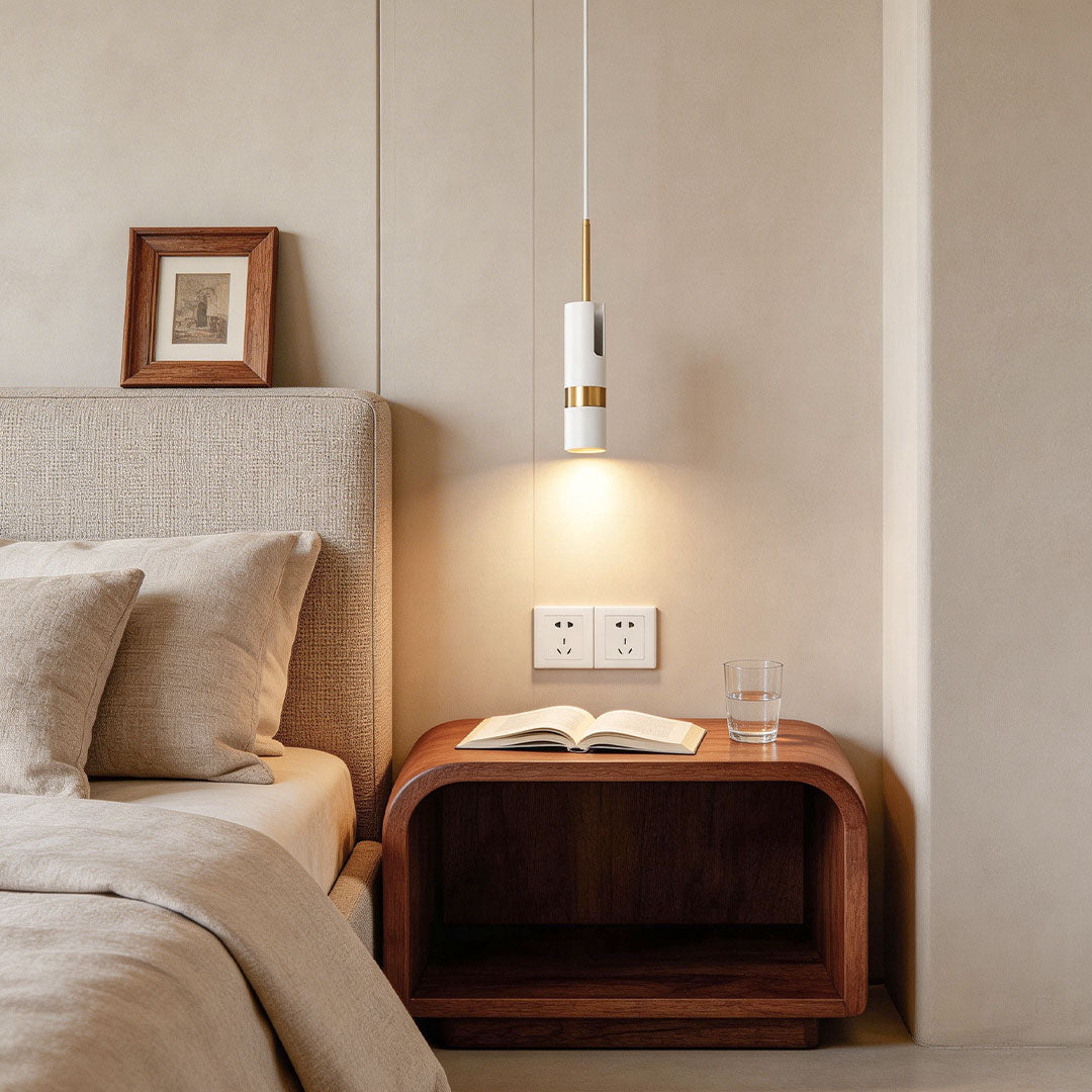 White adjustable cylindrical pendant light over a curved wood nightstand in beige bedrooms.