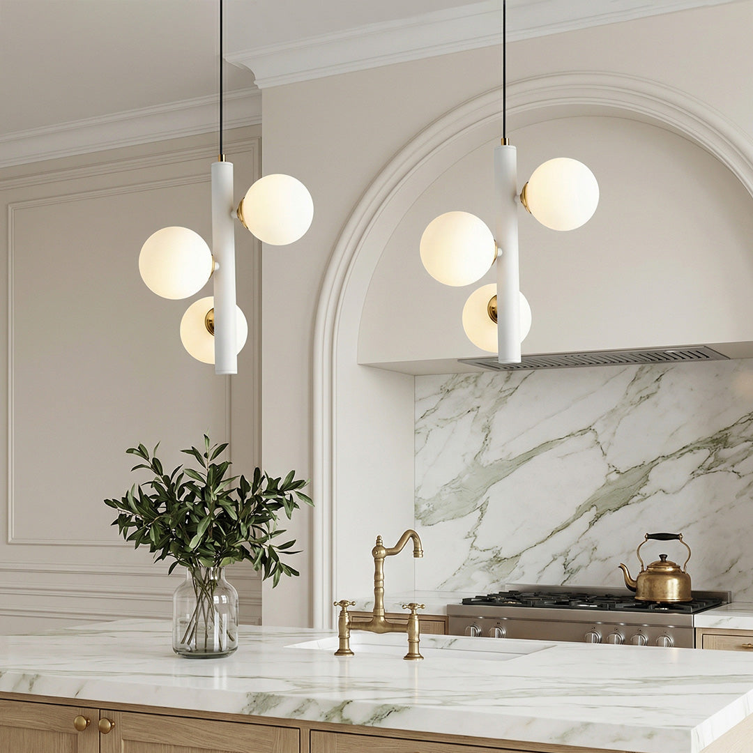 Pair of White and Gold Multi-Light Pendant fixtures over a marble island in an arched kitchen.