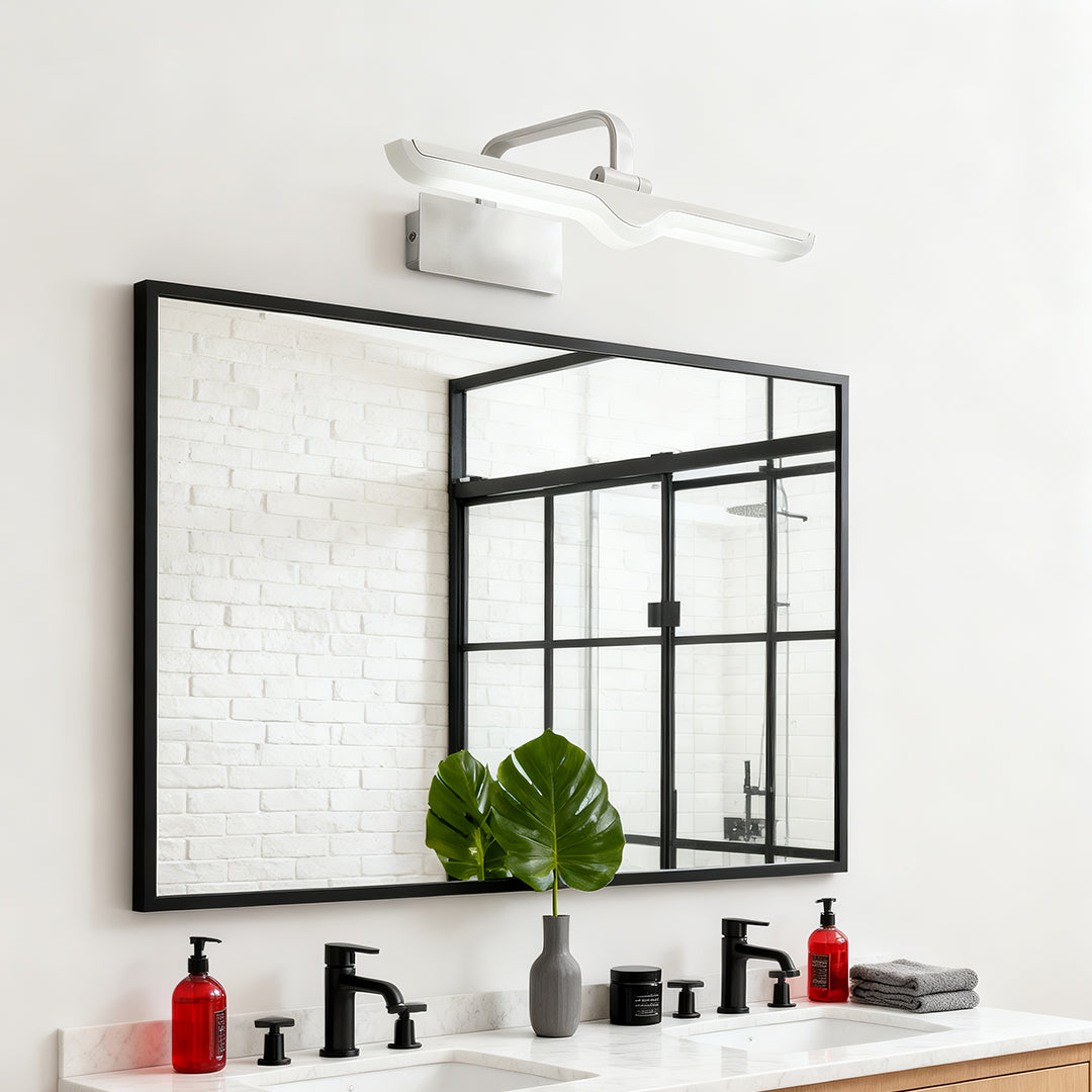 White bathroom vanity light mounted above black-framed mirror in minimalist bathroom setting.