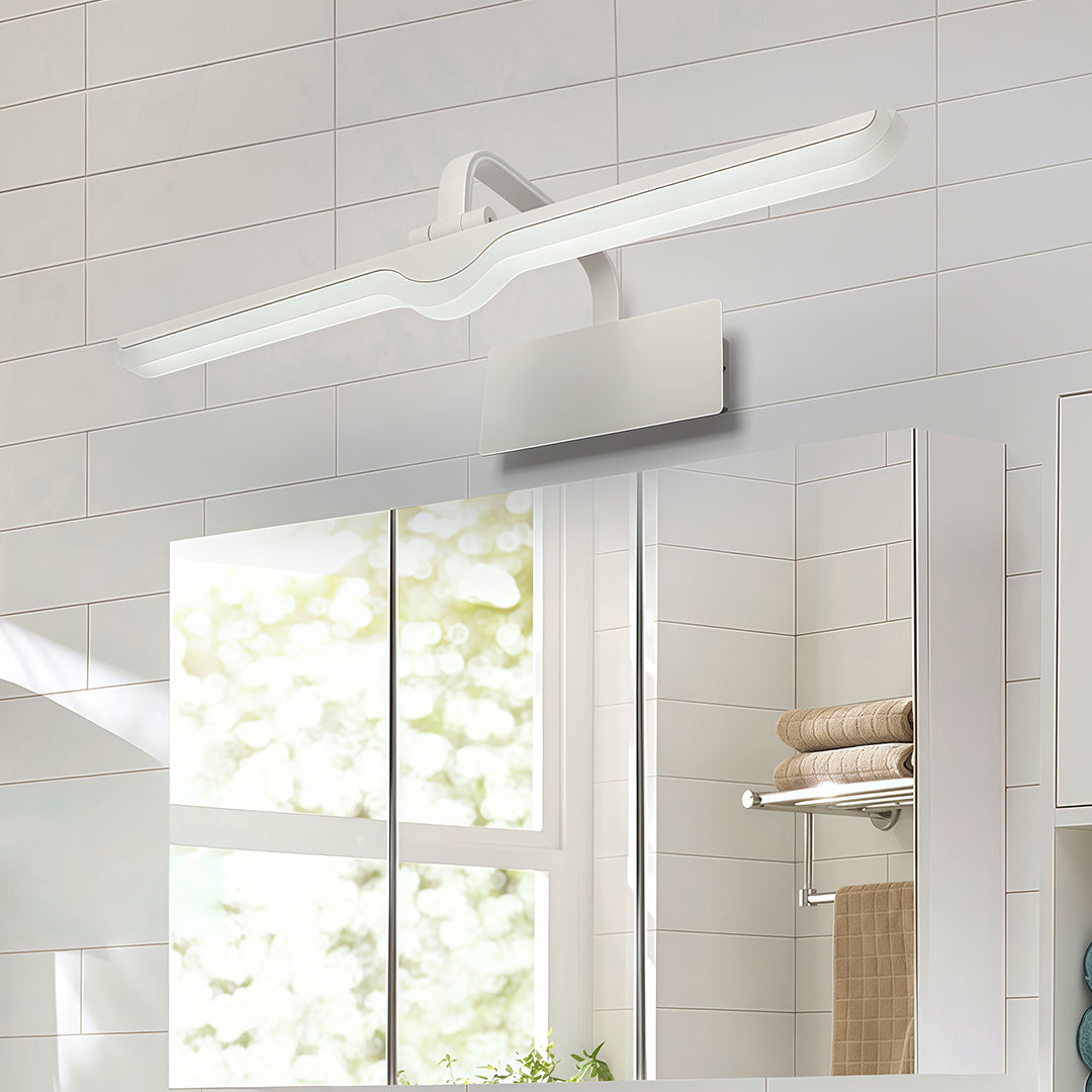 White bathroom vanity light creating even illumination above large mirror in bright white bathroom.