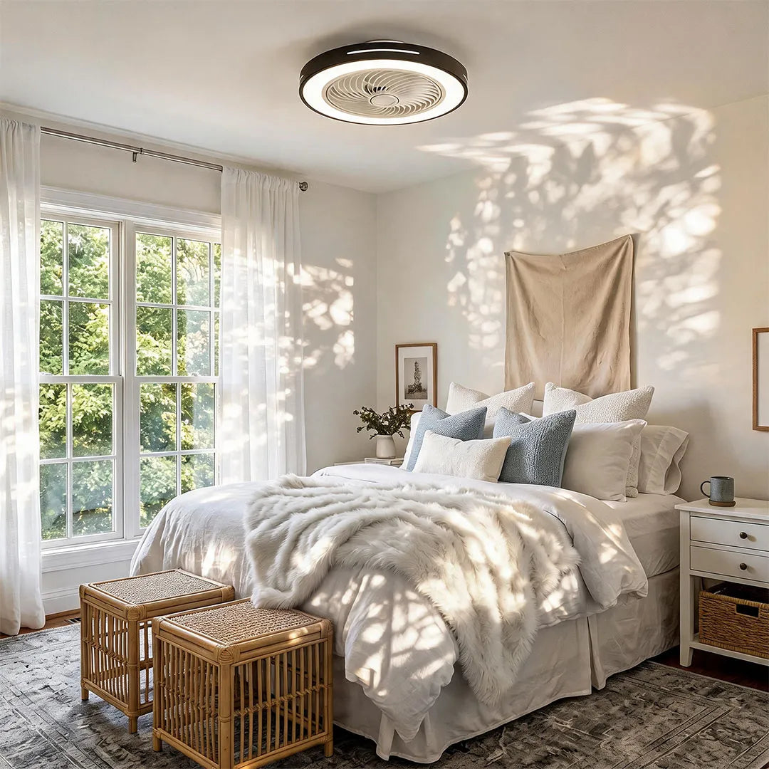 White ceiling fan flush mount with light mounted above a bright bedroom with large windows and layered bedding.