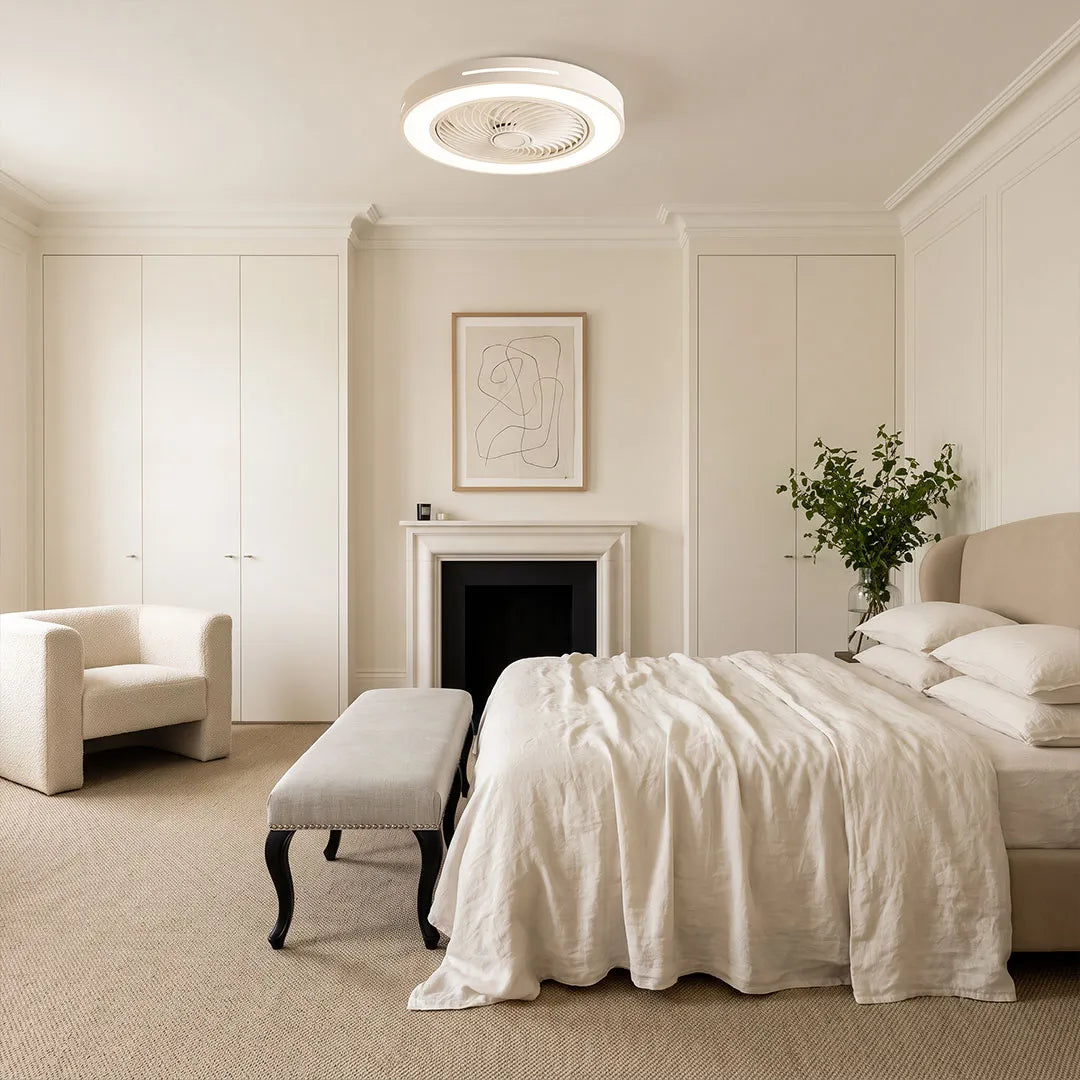 White ceiling fan flush mount with light installed in a bright neutral bedroom with elegant wall paneling.