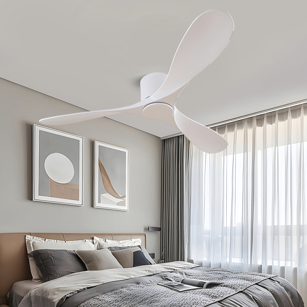 White ceiling fan providing soft airflow in a stylish bedroom with gray curtains.