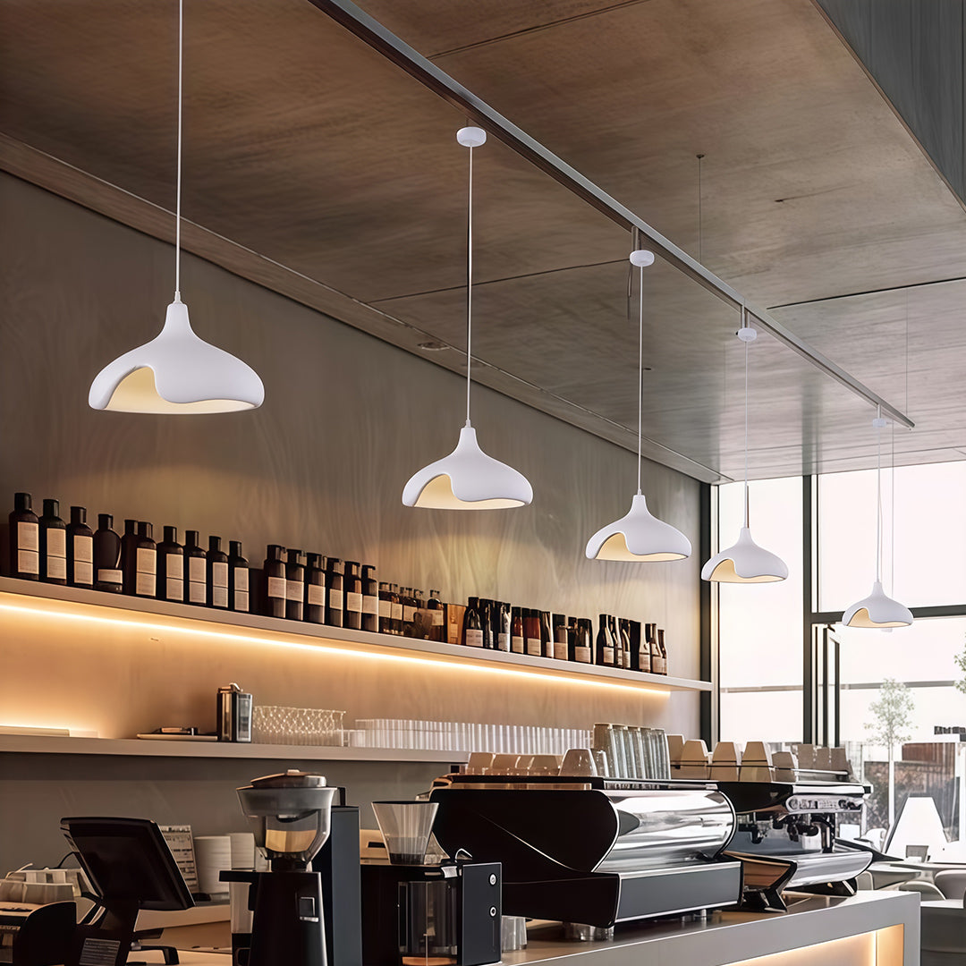 White Cement Pendant Lights above dining table in minimalist restaurant with natural lighting.