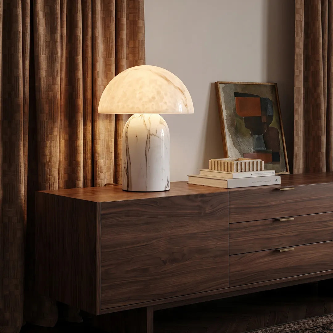 White contemporary table lamps placed on a dark wood dresser, featuring a sculptural white base and a softly glowing dome shade.