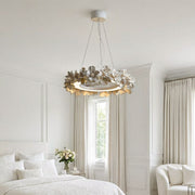 White dining room chandelier installed in a bright bedroom with a floral ring silhouette.