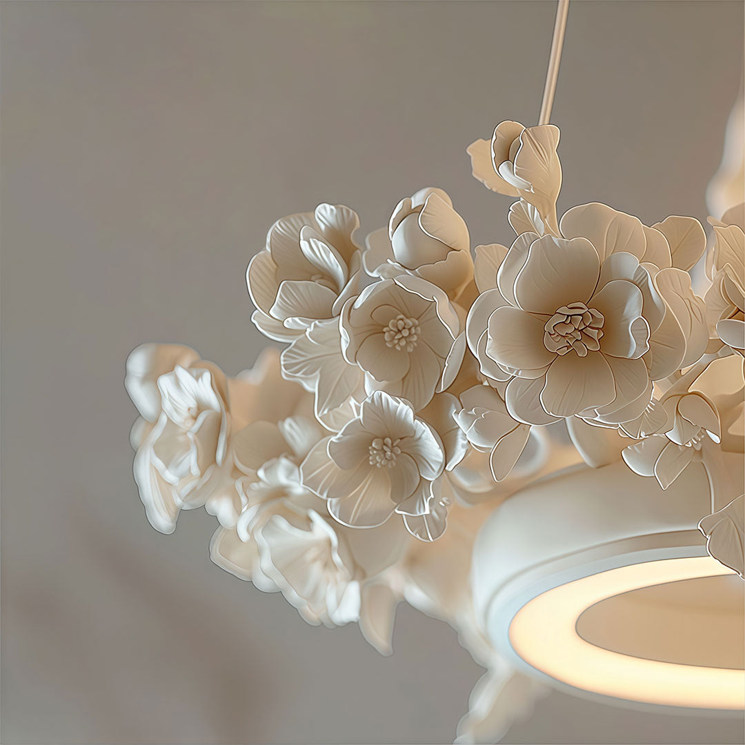 Close-up of white dining room chandelier showing delicate floral petals and illuminated ring details.