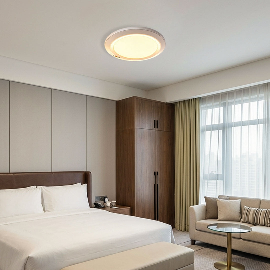 White flush mount ceiling light installed in a bedroom with warm ambient lighting