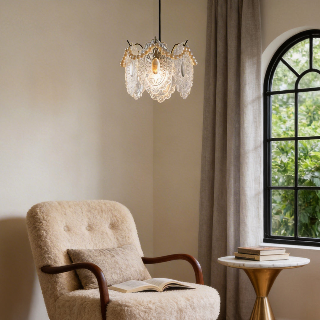 Elegant white glass pendant lights hanging above a cozy armchair near a window with natural light.