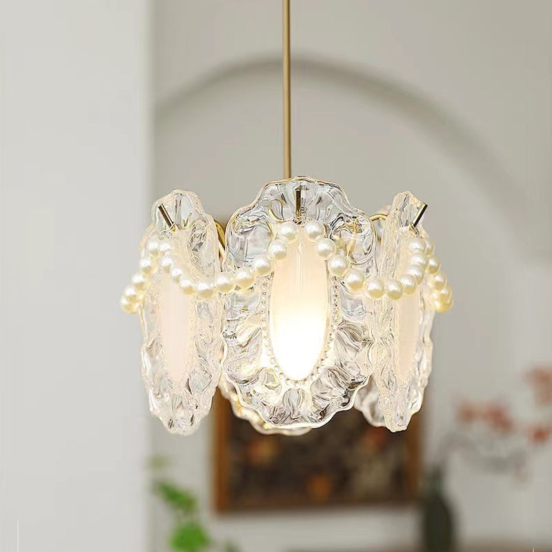 White glass pendant lights with a floral-inspired design hanging above a dining area.