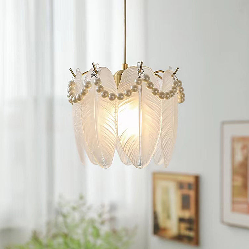 Stylish white glass pendant lights with intricate designs hanging in a modern living room.