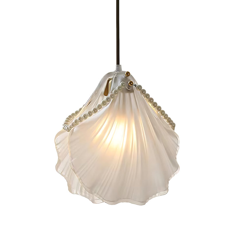 White glass pendant lights with a warm light, creating a cozy atmosphere in a living space.