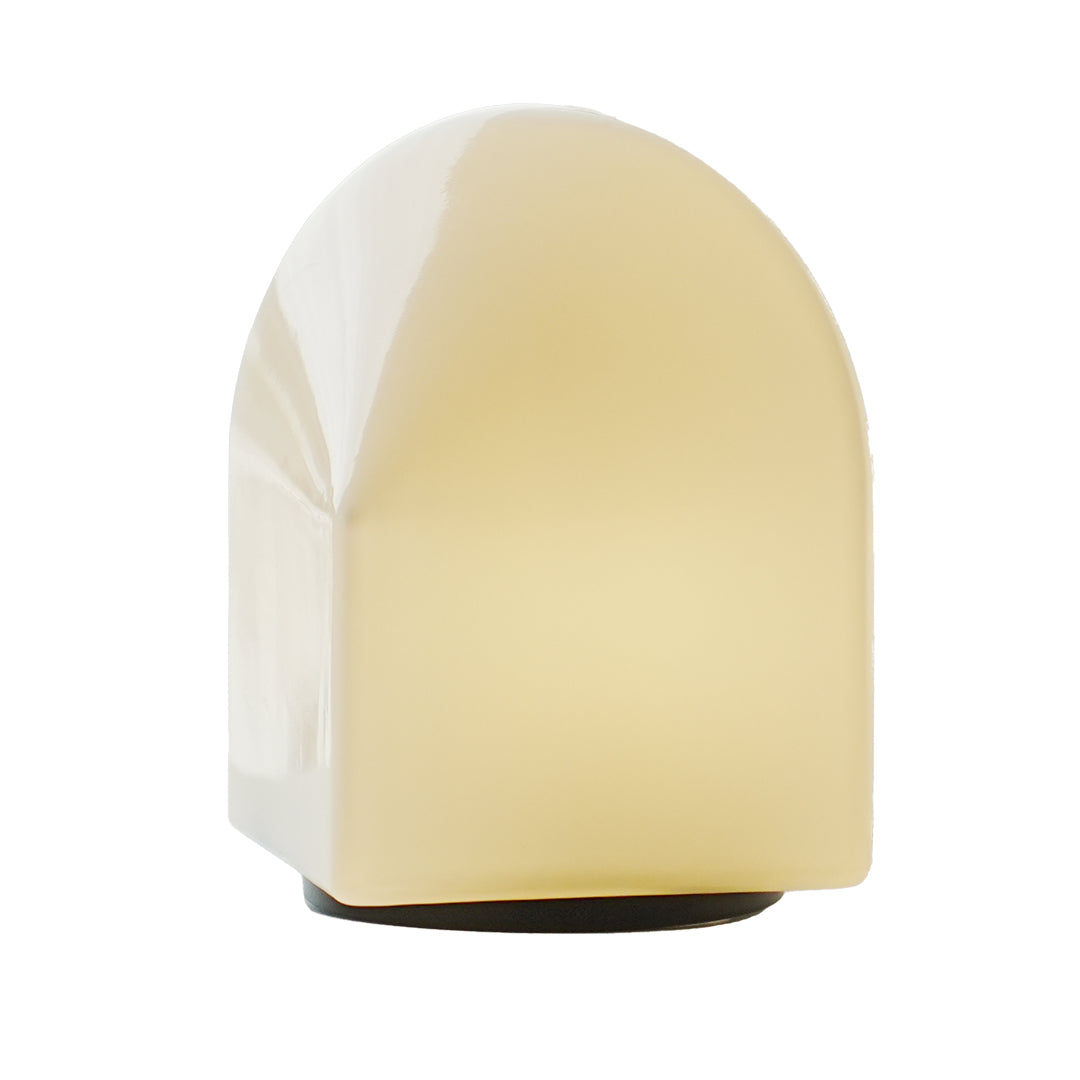 White house silhouette table lamp glowing softly on black base.