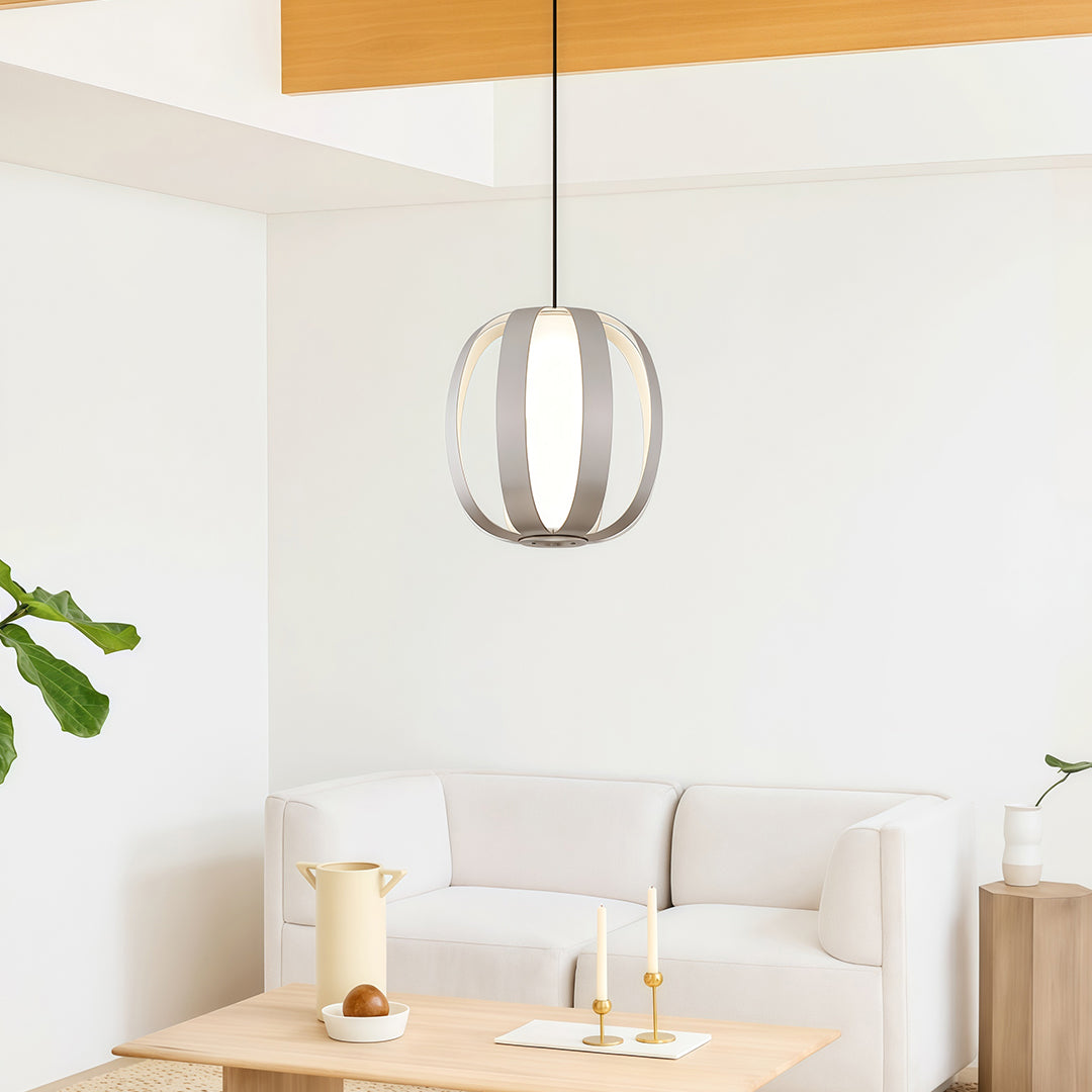White lantern pendant light hanging in bright minimalist bedroom with wood tones and natural light.