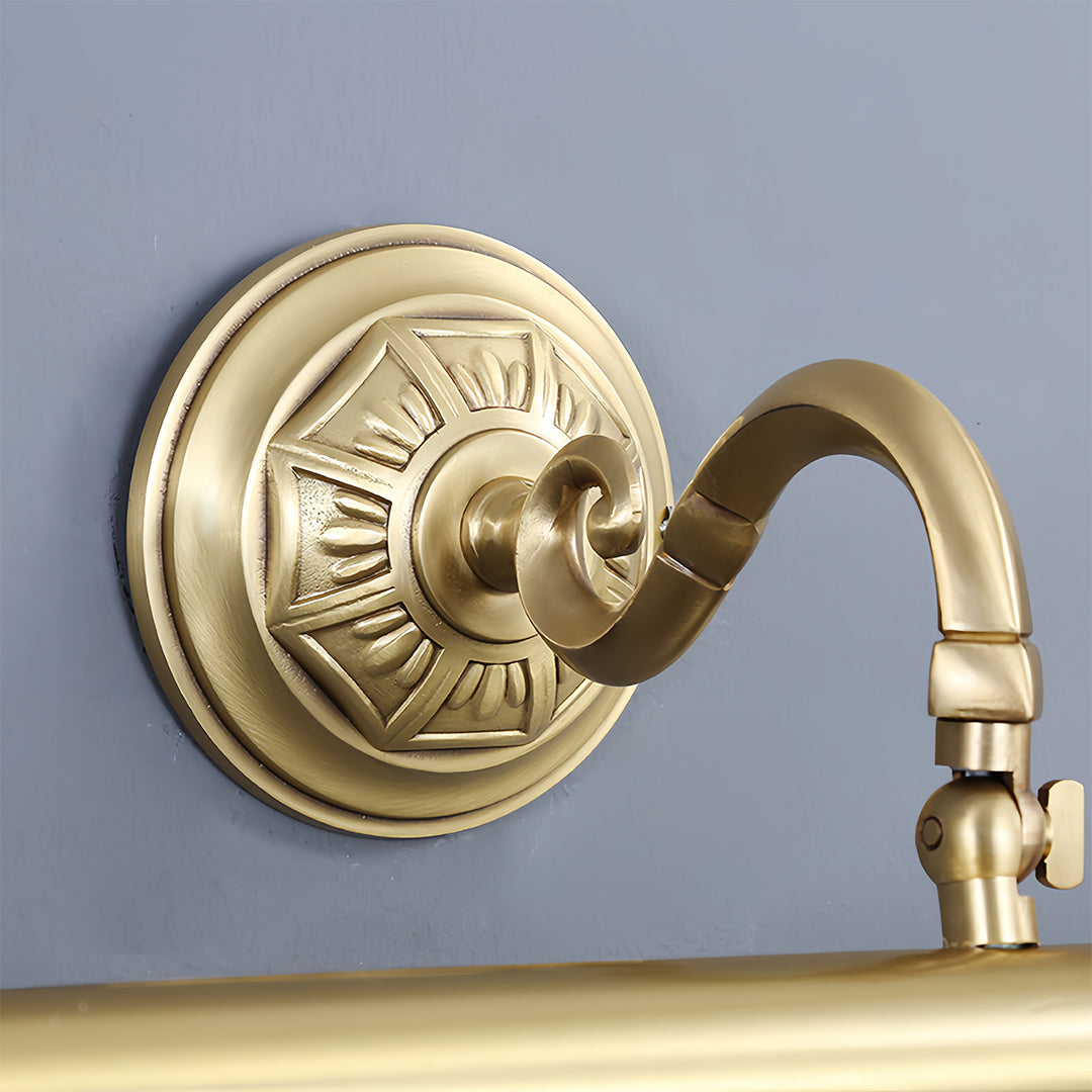 Gold bathroom vanity light installed above white marble vanity with modern mirror