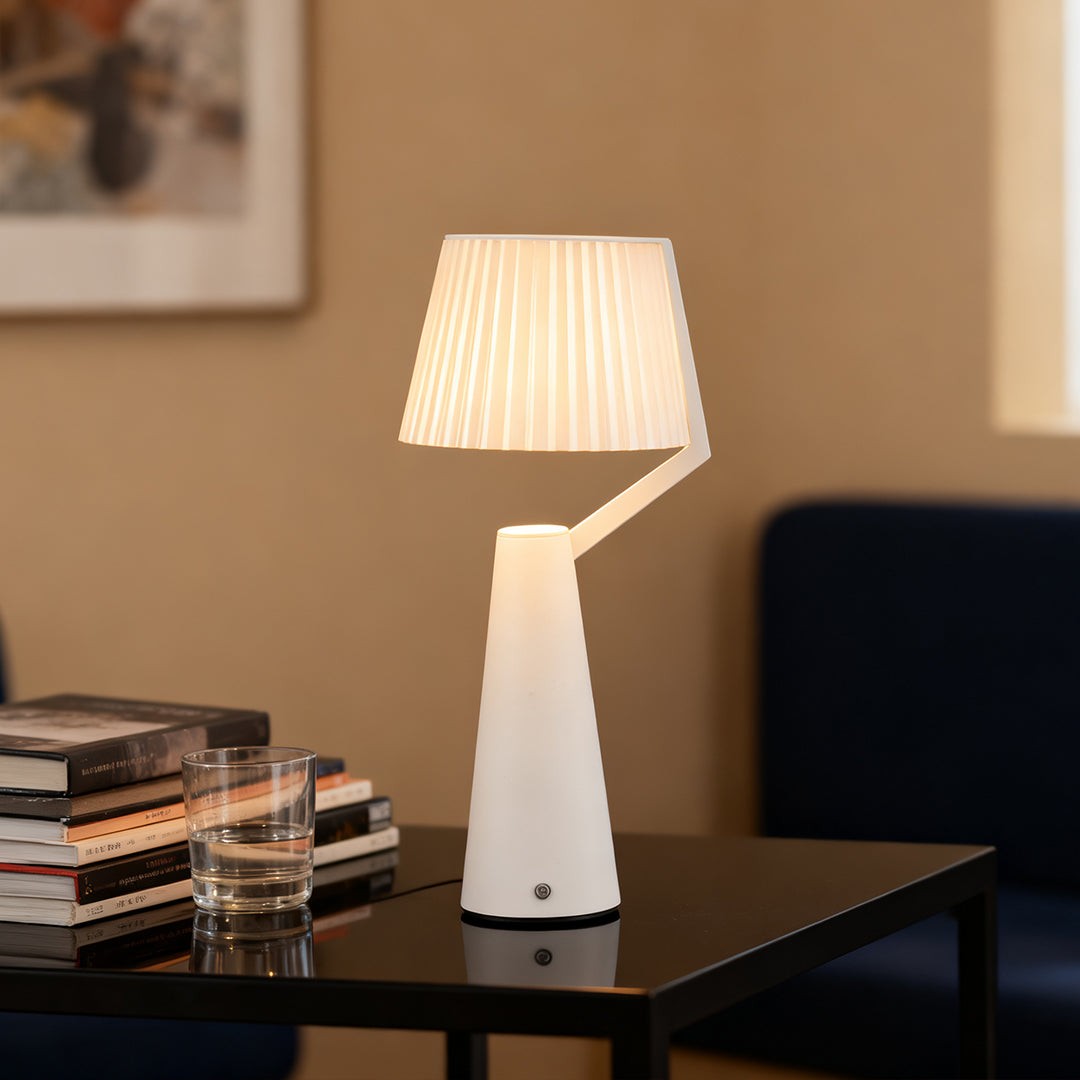 White Nordic table lamp with a distinctive Z-shaped arm and pleated shade on a black modern side table.