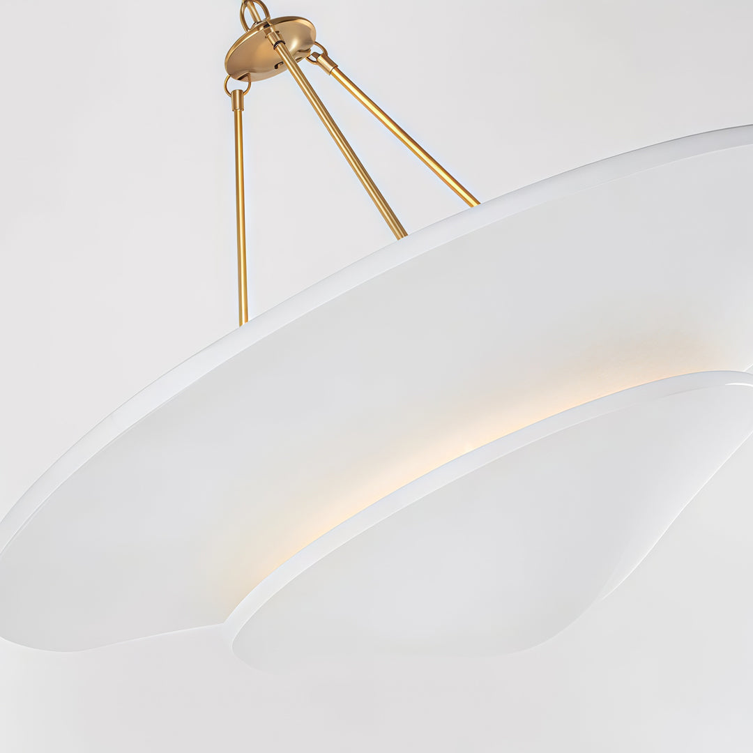 White plaster chandelier close-up showing curved layered shade and brass suspension detail.