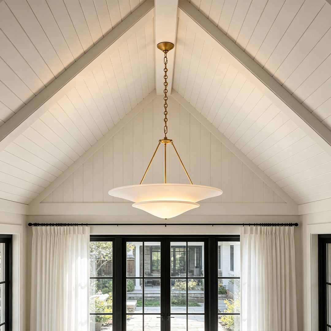 White plaster chandelier hanging in a vaulted ceiling living room with modern farmhouse design.