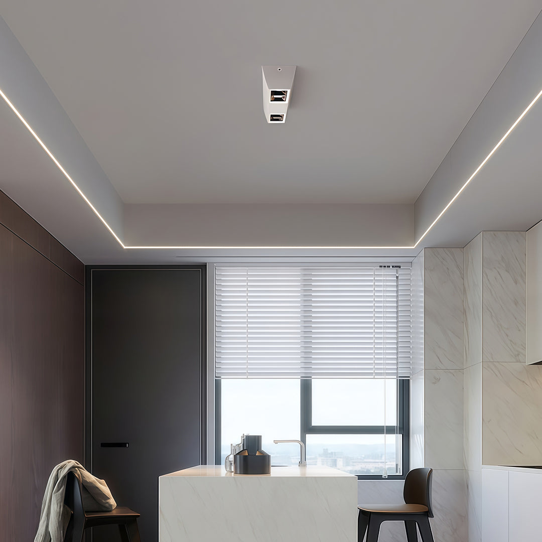 White surface-mounted square downlights fixture providing focused light near a window in a minimalist room.