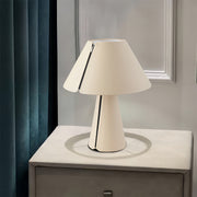 White table lamp providing reading light on modern bedside table surface