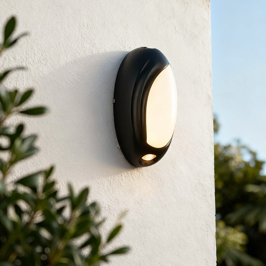Modern up down outdoor wall lights installed on a white exterior wall, projecting warm light above and below.