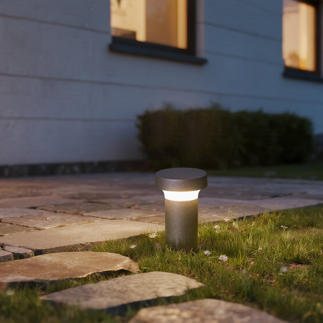 Short cylindrical bollard light with mushroom-style top cap in dark finish