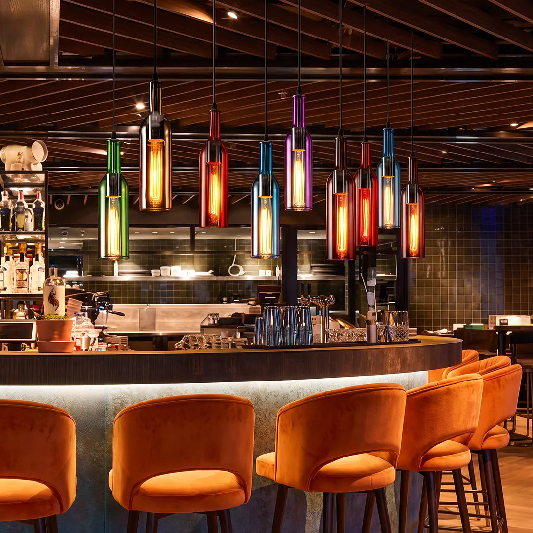 Wine bottle pendant light cluster illuminating a stylish bar with warm seating and a dramatic ceiling design.