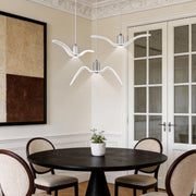 Wing pendant light installed above a round dining table in a modern dining room.