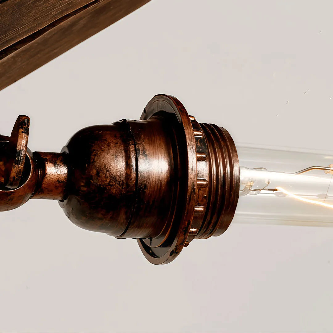 Close-up of wood and metal chandelier showing the antique metal socket and exposed tubular bulb.
