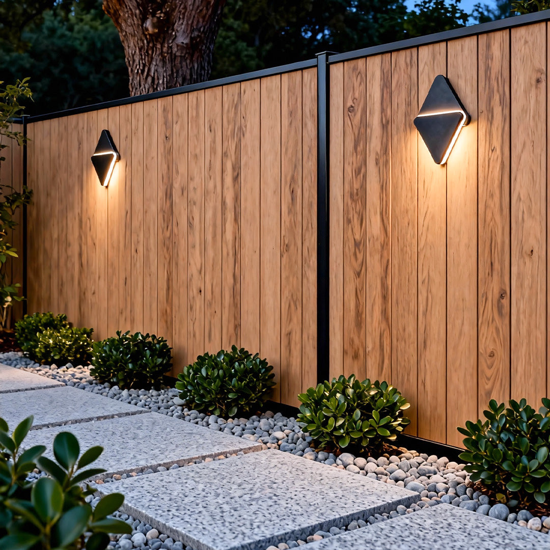 Sleek outdoor lighting sconce mounted on a wooden fence, providing ambient pathway illumination along the yard.