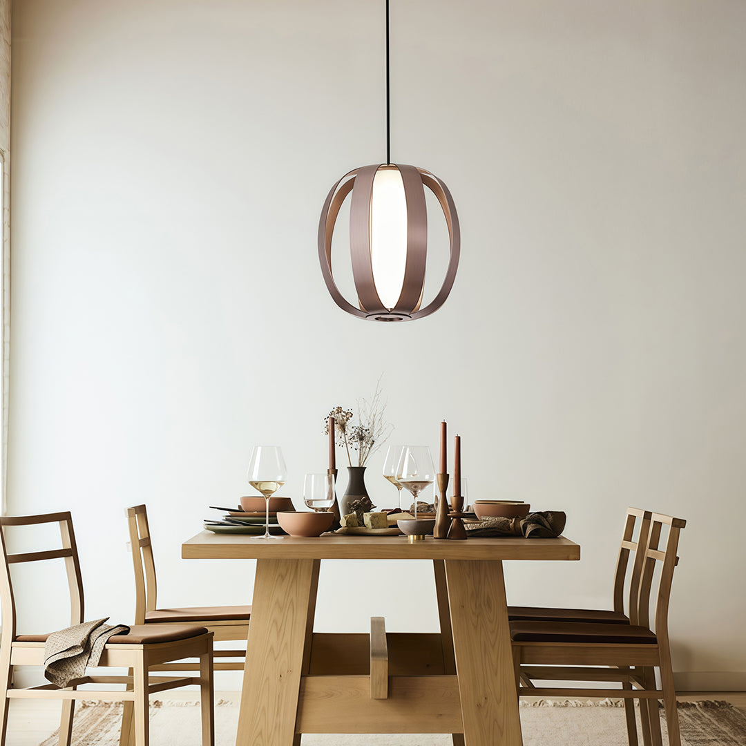 Wood lantern pendant light suspended above round dining table with natural wood chairs.