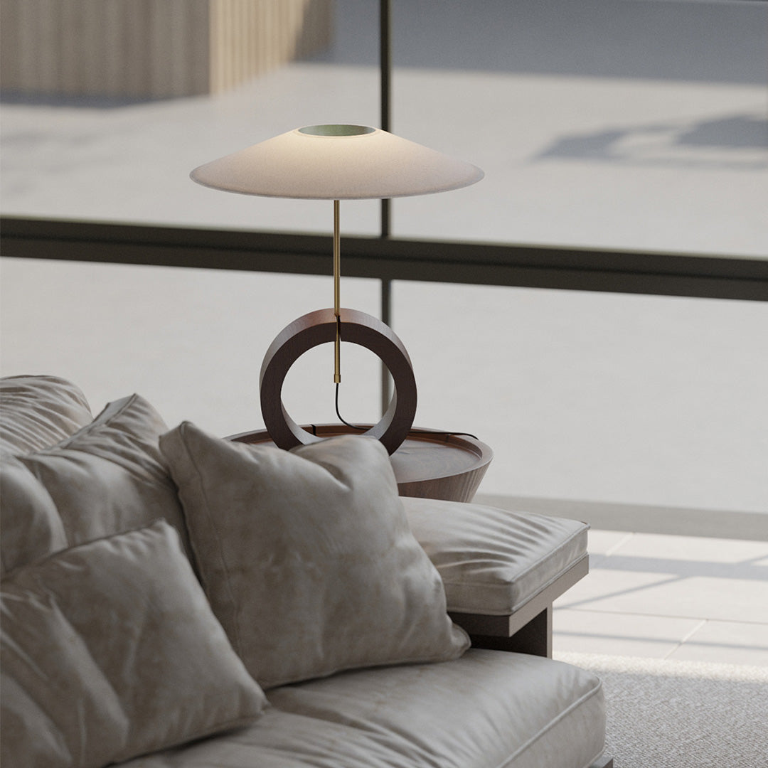 Contemporary wood ring table lamp on bedroom nightstand with warm soft light.