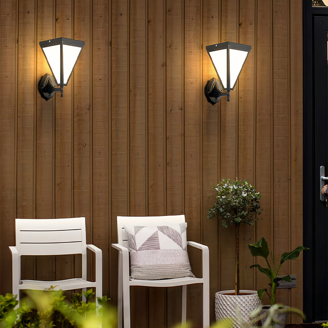 Outdoor solar lights wall mounted on wooden siding near outdoor seating area.