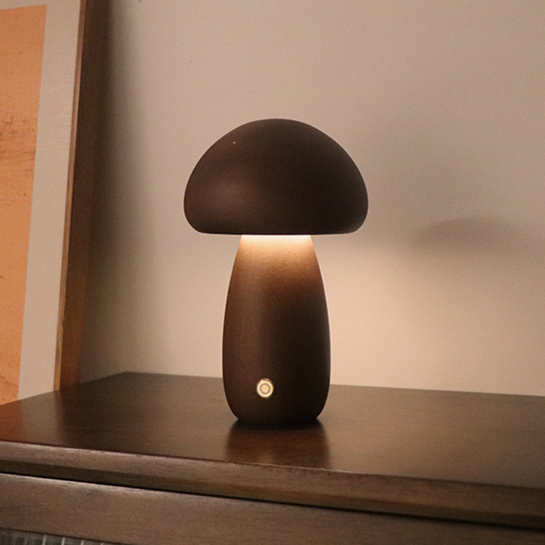Table mushroom lamp with dark cap placed on wooden surface for decorative lighting