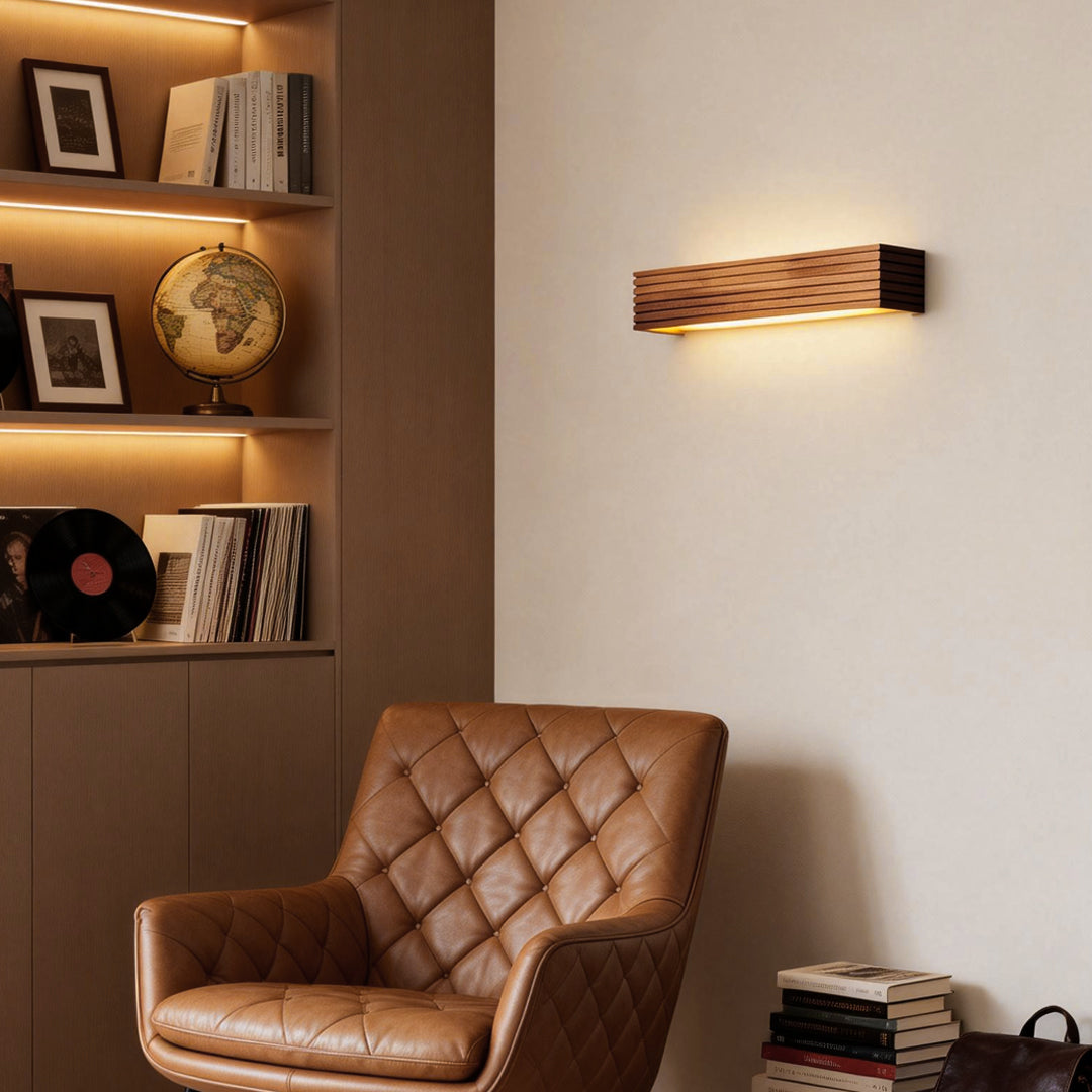 Wooden wall lamp mounted in a cozy reading corner, adding warm ambient lighting to a modern living space.