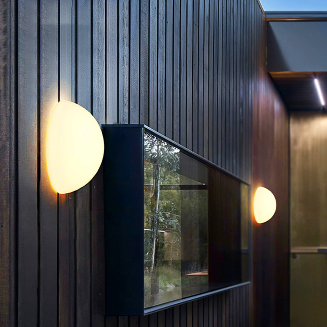 Modern outdoor lighting wall mounted lamp illuminating a vertical wooden façade.