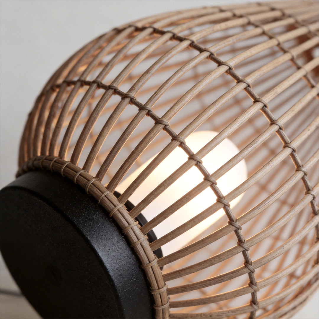 Woven bamboo lantern with a modern design, providing ambient light in a garden.